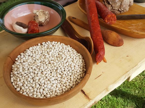 Linsen und Wurst auf einem römisch gedeckten Tisch.