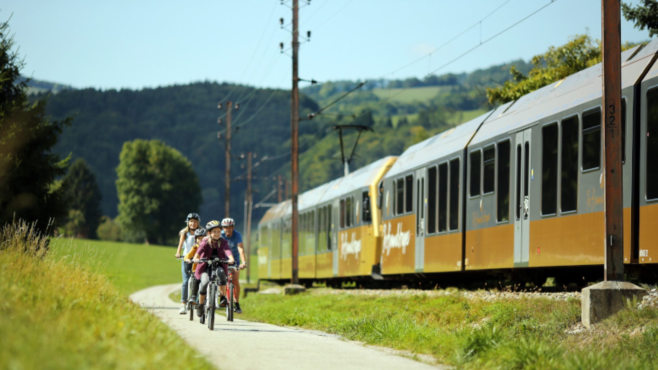Familie beim Radfahren neben der Mariazellerbahn