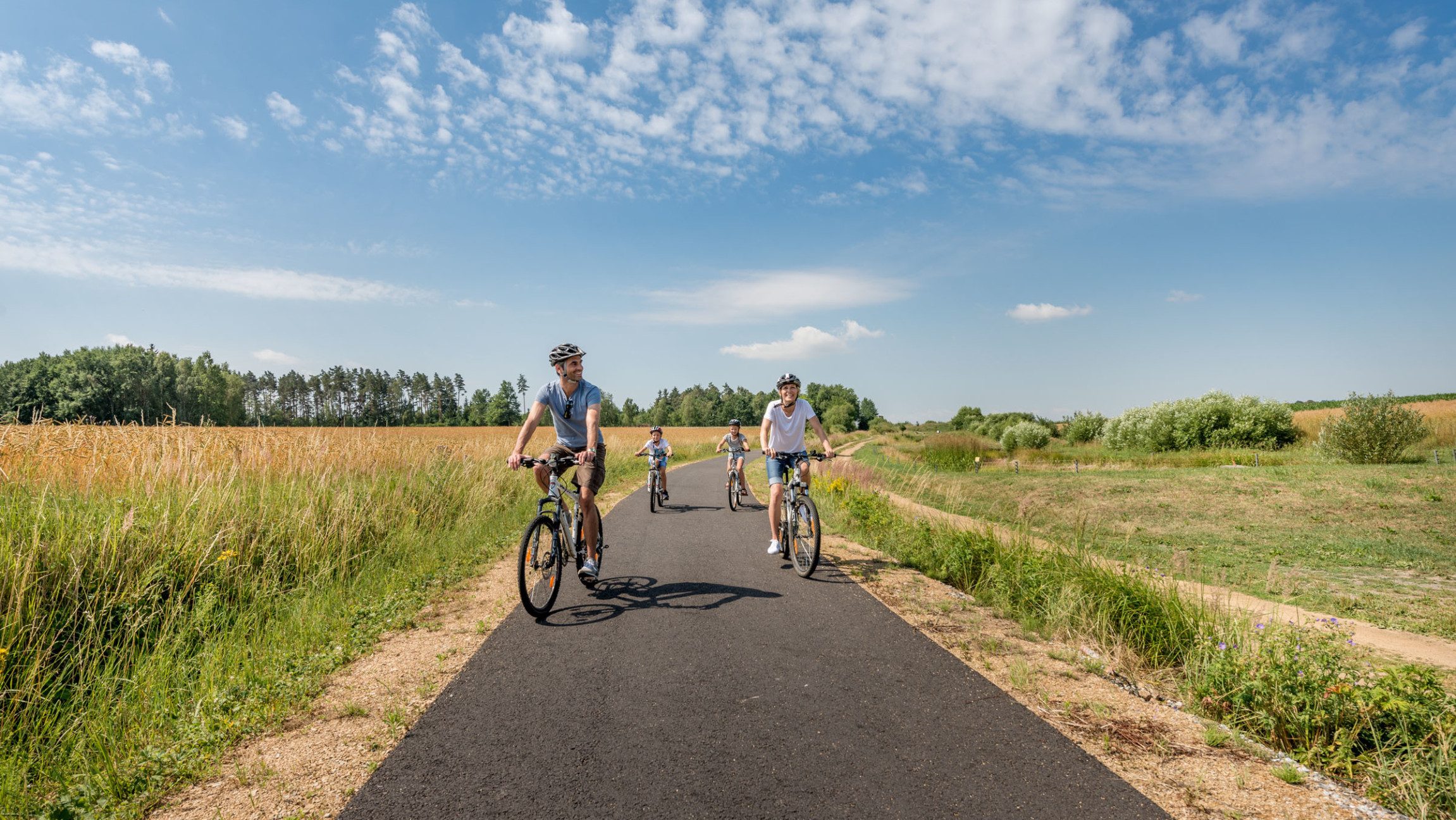 Eine Familie beim Radfahren an der Thayarunde zwischen Feldern