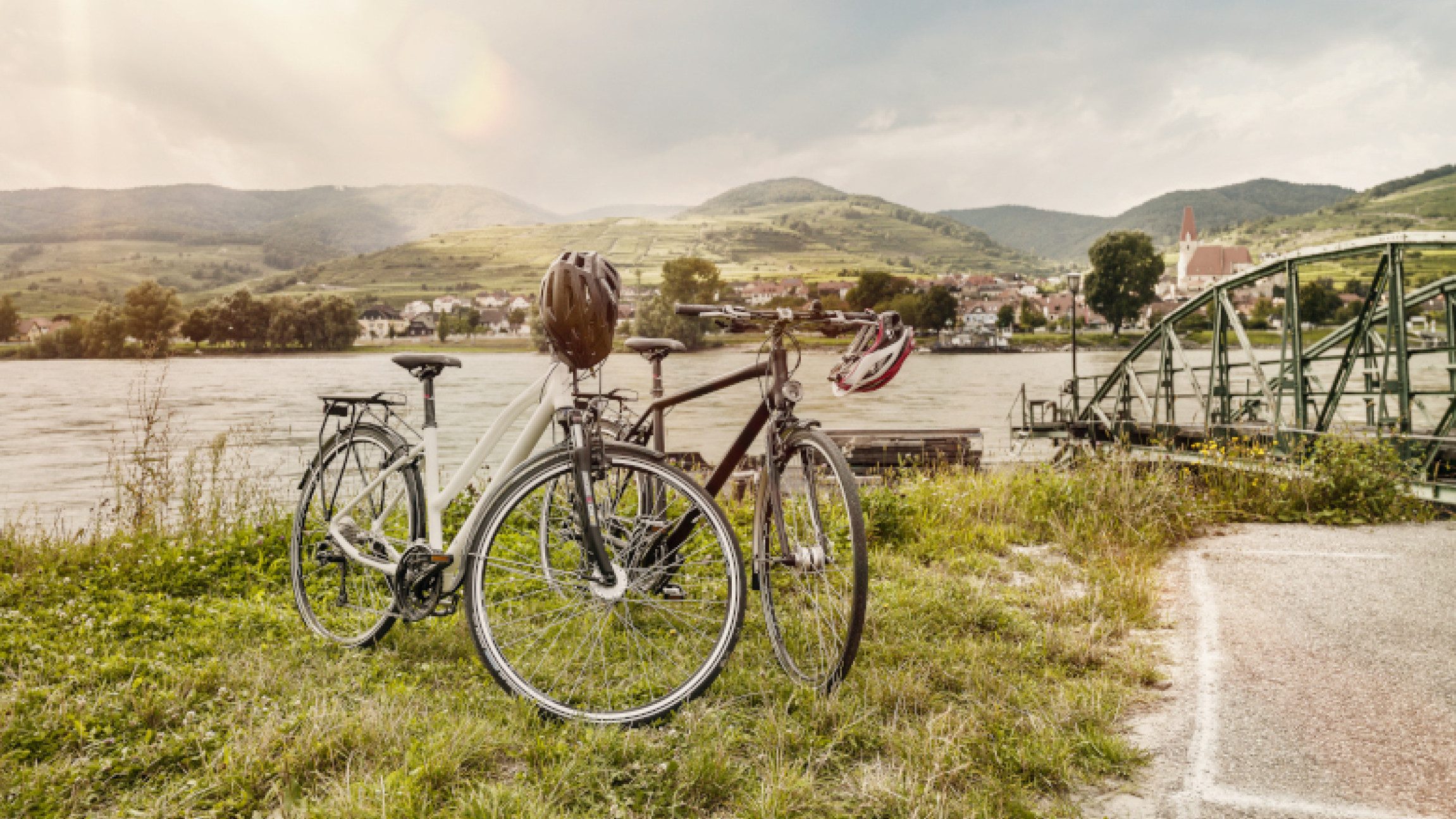 Zwei Räder vor einer Schiffsstation am Donauradweg in der sonnigen Wachau